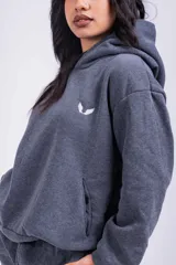 Canguro blanco con capucha, bolsillos laterales y logo pequeño bordado en negro en el pecho.