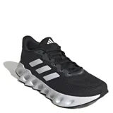 Championes de running Adidas modelo Switch Run, color negro con detalles en blanco. Presentan una parte superior de malla transpirable, entresuela de EVA con diseño de rebajes y suela exterior Adiwear para mayor tracción.