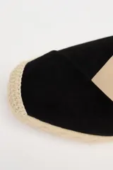 Zapato destalonado con tacón tipo cuña, color negro, con combinación de materiales en el corte y tiras para atar en el tobillo.