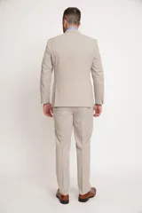 Ambo de dos piezas color beige, compuesto por saco de corte slim fit con solapas clásicas y pantalón de vestir a juego con corte recto.