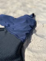 Trikini negro y azul marino, con diseño asimétrico de un solo hombro y abertura lateral.