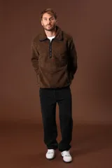 Cazadora de borreguillo color marrón, con cuello alto y cierre frontal parcial con cremallera. Presenta bolsillos laterales y diseño de manga larga.