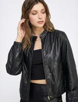 Camperita estilo bomber de eco cuero negra, con cuello mao y cierre frontal metálico. Presenta mangas largas con puños elásticos y elástico en el bajo.