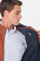 Chaleco deportivo rojo de polar con forro e interior en color azul combinado, cierre frontal y bolsillos delanteros con cierre metálico personalizado. Incluye dos bolsillos interiores con cierre y logo bordado en el pecho.