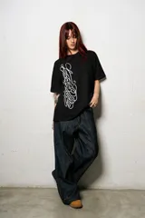 Remera negra de corte regular fit, confeccionada en jersey de algodón, con estampa frontal de diseño caligráfico en color blanco.