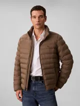 Campera puffer de peso medio Calvin Klein, con diseño acolchado, cuello alto y cierre frontal de cremallera. Presenta el logo de la marca estampado en el pecho.