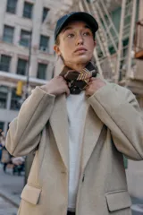 Blazer de corte recto y diseño minimalista, confeccionado en tejido de paño suave color beige. Presenta cuello con solapas clásicas, cierre frontal con un solo botón y dos bolsillos delanteros con solapa.