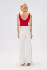 Pantalón de jean color crudo, de corte recto y tiro alto, con pespuntes a contratono y cinturón con hebilla redonda.