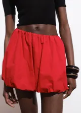 Short de estilo globo con cintura elástica, confeccionado en algodón con forro interior y bolsillos laterales.