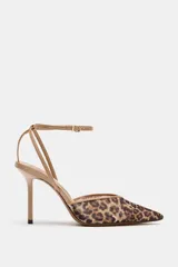 Zapato de tacón alto fino y destalonado, confeccionado en mesh con estampado animal print tipo leopardo. Presenta acabado en punta fina y tiras finas con hebilla ajustable a la pulsera del tobillo.