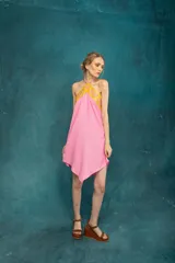 Vestido corto de lino color rosa con detalle de guarda pampa en cuero color amarillo en el escote halter.