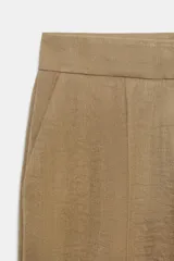Pantalón recto de tiro bajo en color verde militar, con nervios marcados en la parte delantera, bolsillos frontales y cierre con cremallera, botón interior y ganchos.