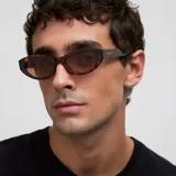 Lentes de sol con montura de acetato color carey (tortoise) y forma ovalada/cat eye. Las lentes son de color marrón polarizadas.