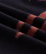 Remera boxy de algodón negro con cuello redondo, mangas cortas y estampa en la espalda con la inscripción "Spider-Man" en tono rojo con efecto desgastado.