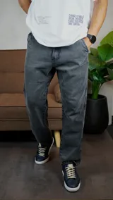 Pantalón de jean con corte recto y acabado lavado en color gris oscuro. Presenta cierre frontal con botón y bolsillos laterales.