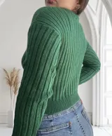 Sweater verde de punto canalé, con cuello redondo y mangas largas.
