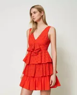 Vestido corto de algodón color rojo con bordado inglés, sin mangas, con escote en pico pronunciado, fruncido floral, volante de popelina en el bajo y cierre con cremallera lateral.