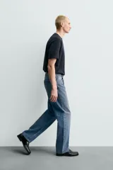 Pantalón de jean con corte recto desde la cadera y leve ensanchamiento en el bajo. Presenta tiro medio, cinco bolsillos, cierre frontal con cremallera y botón, y un acabado con efecto lavado.