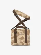 Bolso tipo sobre o cartera pequeña de Carhartt, con estampado de camuflaje en tonos beige y marrón. Presenta un bolsillo frontal de malla y cierre principal con cremallera. Incluye correa ajustable para llevar al hombro o cruzado.