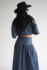 Falda larga negra con diseño de caderín y tablas.