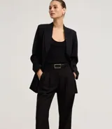 Pantalón de sastrería corte recto confeccionado en crepé, con pliegues delanteros y cintura con detalle cruzado. Presenta un diseño estructurado y elegante.