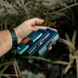 Billetera tipo tarjetero de cuero negro con caja de aluminio interna y sistema de deslizamiento para tarjetas. Cuenta con cierre mediante broche a presión.