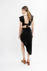 Vestido midi negro con bordado de flores color naranja, escote en V, corte en la cintura y falda asimétrica con abertura lateral.