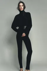 Jersey de punto liso color negro, con cuello subido y mangas largas de diseño murciélago con sisa ancha que se estrecha hacia la muñeca.