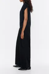 Pantalón de vestir color marrón claro, de corte ancho, con pinzas en la parte delantera, bolsillos laterales y trabillas en la cintura.