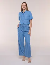 Pantalón fluido de estilo pull-on y silueta amplia confeccionado en lyocell de tacto sedoso, color azul. Cuenta con cintura totalmente elastizada con cordón ajustable, amplios bolsillos delanteros aplicados tipo parche y pierna de corte ancho y recto terminada con dobladillo deshilachado.