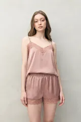 Short de pijama negro de tejido satinado con leve elasticidad, silueta relajada, cintura elastizada y detalle de encaje floral en el borde inferior.