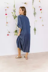 Vestido azul denim con escote en V, mangas cortas y detalle de nudo en la cintura.