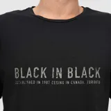 Remera blanca de corte regular con cuello redondo y mangas cortas. Presenta un estampado frontal con la frase 'BLACK IN BLACK' en color negro.