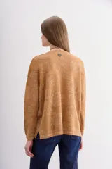 Sweater de moldería relajada, color camel, con escote redondo y manga larga. Tejido jacquard con diseño floral en lurex a tono que simula transparencias.