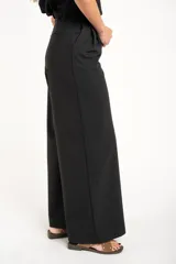 Pantalón negro de vestir, de corte wide leg y tiro medio.