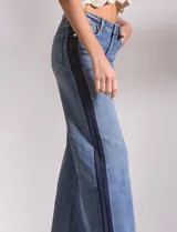 Jean wide leg de tiro medio-alto, color azul con franja vertical en denim oscuro en los laterales. Cuenta con cinco bolsillos y pretina con pasadores, botón y cierre.