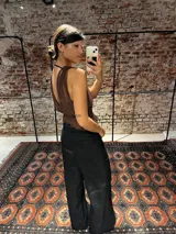 Top de microtul color marrón con escote profundo, diseño cruzado y faja en la cintura con detalle de volados en el ruedo. Presenta una estructura de doble capa para mayor opacidad y ajuste regulable en la espalda.