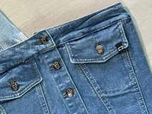 Top strapless de jean con botones blancos y ruedo desflecado.