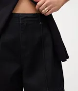 Bermuda midi de jean color negro, con cintura media, cierre de gancho, bolsillos laterales y detalle de costura frontal vertical.