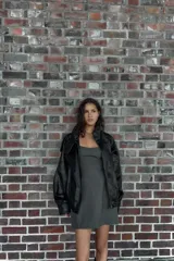 Vestido corto de corte ajustado con escote tipo bustier y tirantes finos. Presenta costuras verticales que definen la silueta y cierre posterior con cremallera oculta.