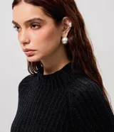 Blusa cropped de punto chenille color negro, con cuello alto y mangas largas raglán. Presenta una textura acanalada y pequeños puntos brillantes aplicados en el frente.