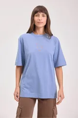 Remera de algodón color camel, corte holgado y manga corta, con un pequeño bordado de un sol en el pecho.