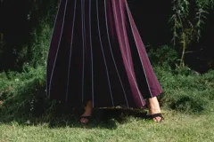 Falda larga color borgoña con finas rayas verticales blancas y cintura elastizada.