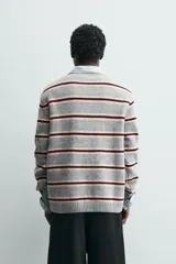 Sweater de punto con diseño de rayas horizontales en tonos gris, rosa y marrón. Presenta cuello redondo, manga larga y terminaciones en rib acanalado.