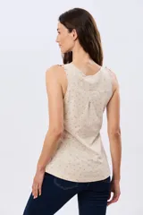 Musculosa de algodón color beige con delicado estampado floreado, escote redondo y pequeños volados en las sisas.