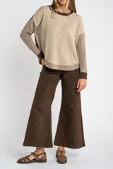 Sweater de punto con diseño color block en tonos beige, marrón y bordó, de cuello redondo y manga larga con puños acanalados en contraste.