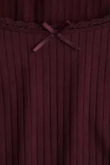 Remera de manga larga ajustada al cuerpo, confeccionada en tejido acanalado color bordó. Presenta un escote pronunciado ribeteado en encaje y un pequeño moño de satén en el centro del escote.