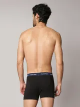 Pack de tres bóxers tipo trunk de algodón elástico, con cintura elástica distintiva de la marca con logo repetido. Incluye tres unidades en color negro con cinturas en azul marino, blanco y verde.