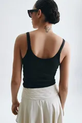 Musculosa de escote redondo y tirantes finos, confeccionada en tejido rib con ajuste entallado.