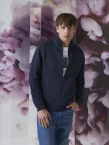 Campera tipo fleece color azul marino con cierre frontal completo, cuello alto y textura acolchada en el panel frontal. Cuenta con puños y ruedo acanalados.